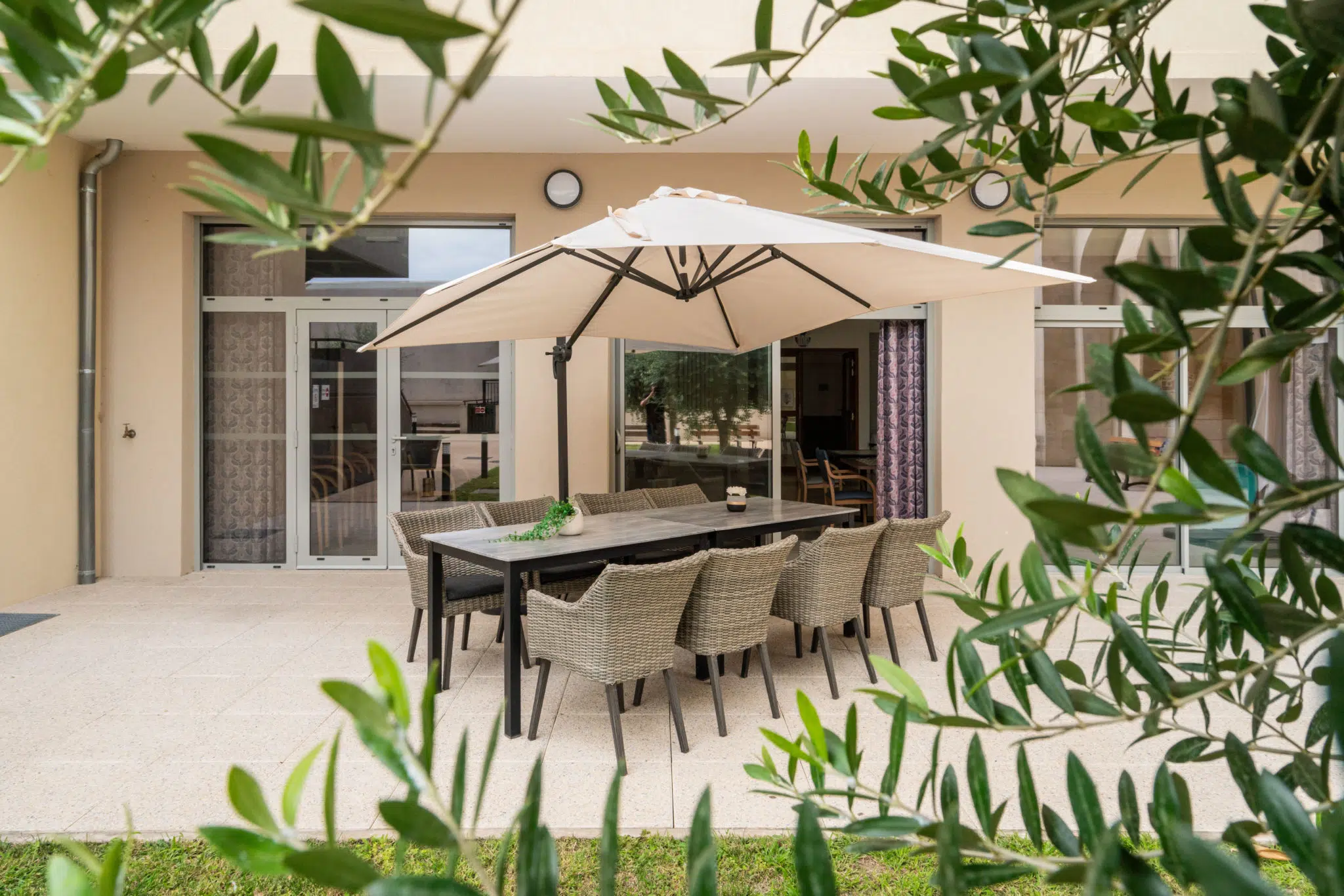 Terrasse extérieure de l'EHPAD Clair Soleil à Nîmes avec tables, chaises et parasol