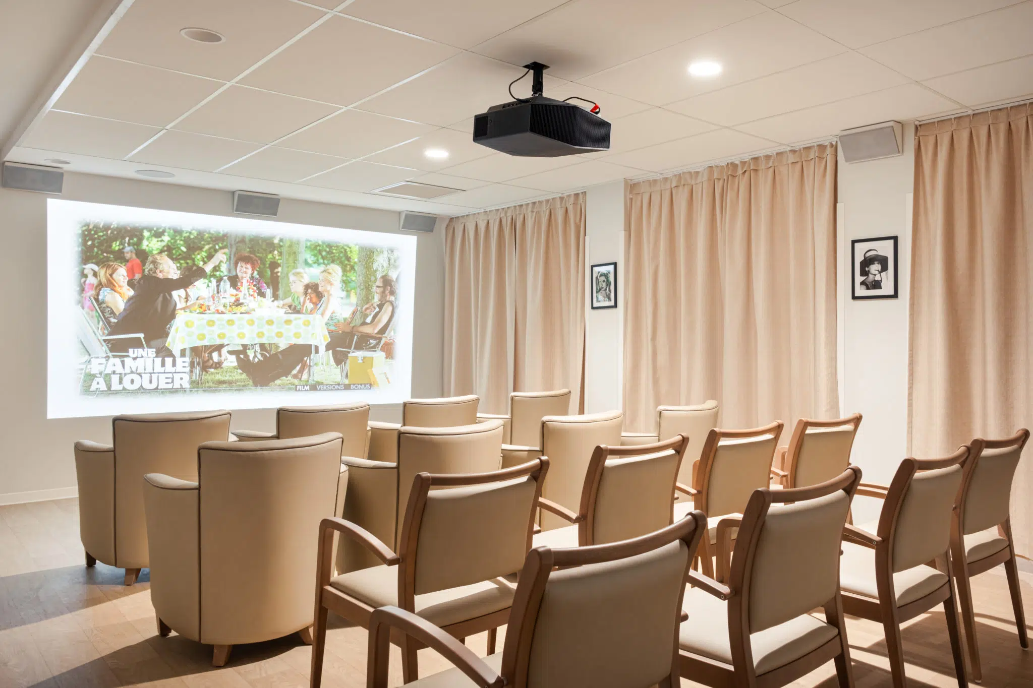 Fauteuils et chaises avec accoudoirs dans la salle de cinéma de l'EHPAD